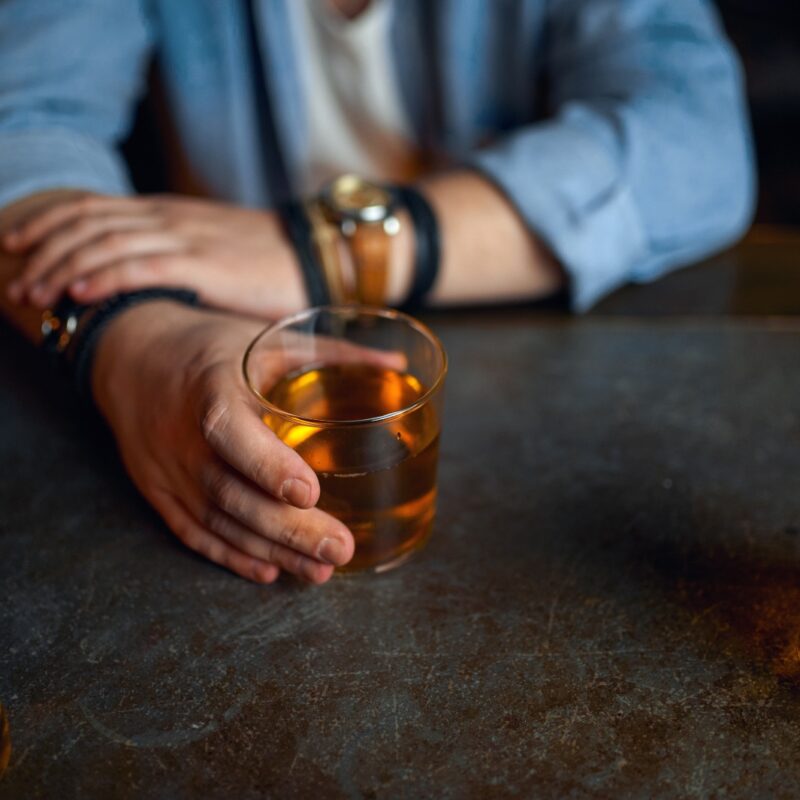 Drunk man pours alcohol at the counter in bar. One male person resting in pub, human emotions and leisure activities, depression  paws symptoms