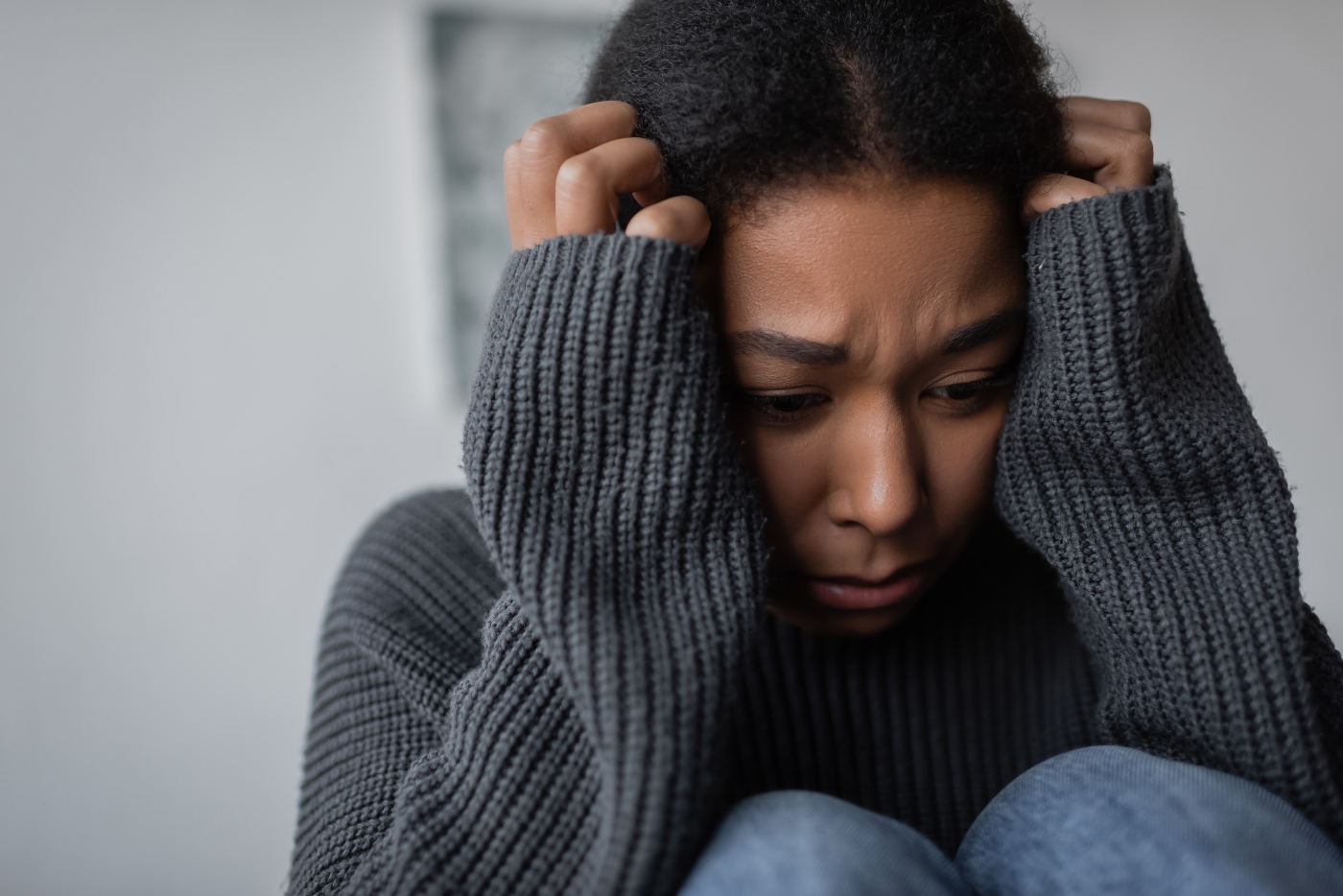 woman with anxiety in recovery curled up in a ball upset