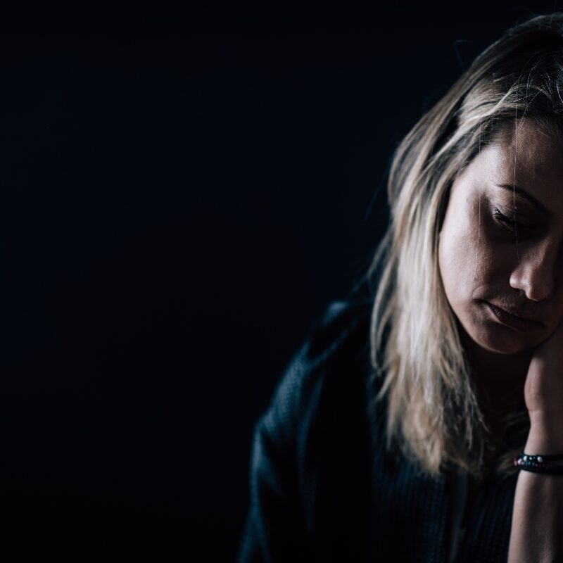 depressed woman in dark room  seasonal depression and addiction