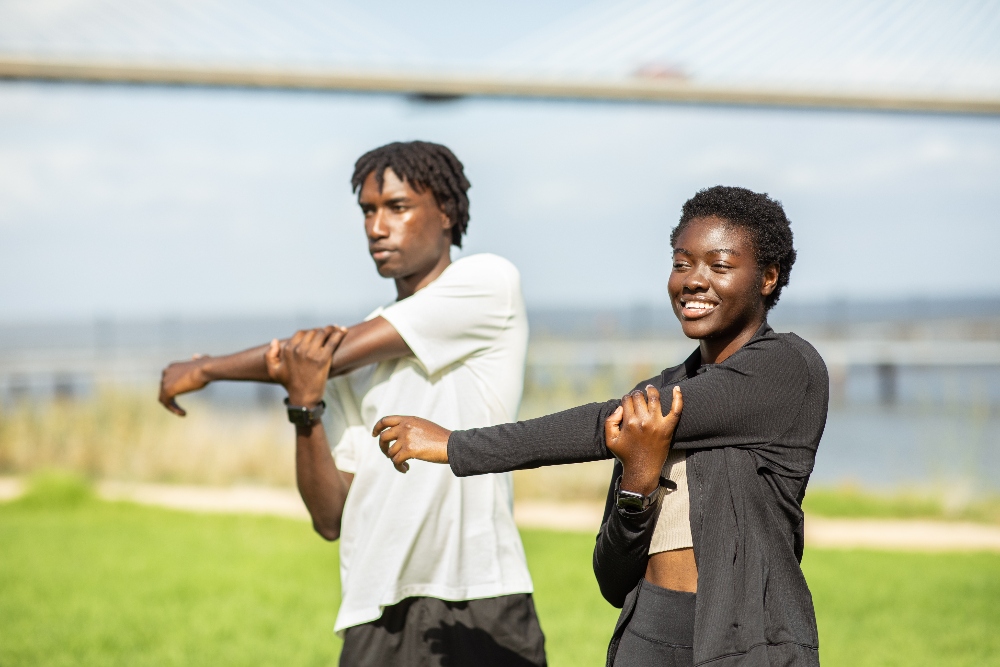 young adults stretching at a park  how can i create a healthy routine in addiction recovery