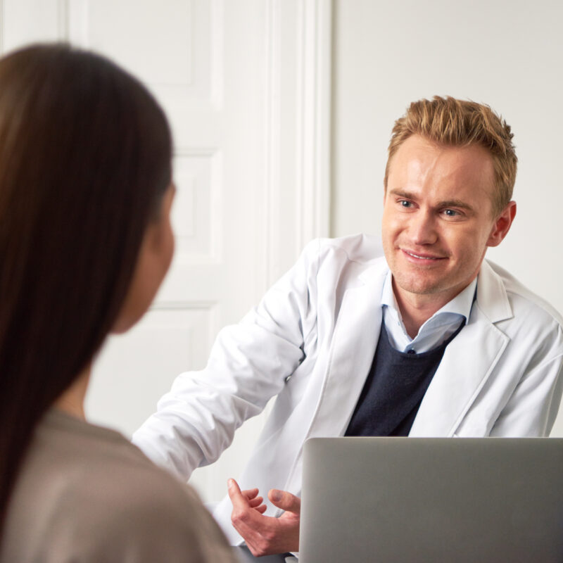 A doctor smiling at a patient while discussing inpatient vs outpatient rehab